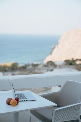 a laptop on a table with a view of the beach at Mon Signor in Kamari