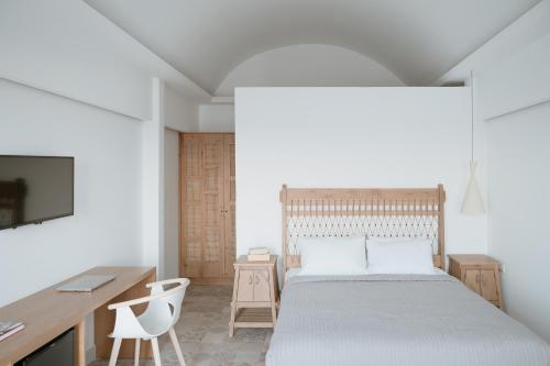a bedroom with a bed and a desk and a tv at Mon Signor in Kamari