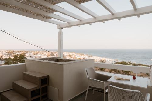 a balcony with a table and chairs and the ocean at Mon Signor in Kamari