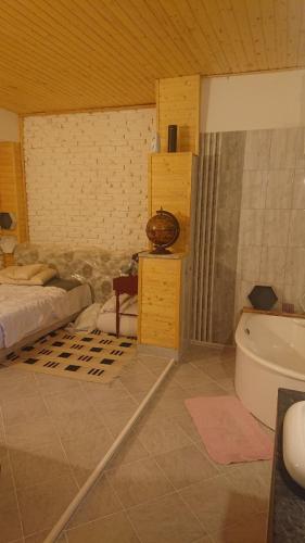 a bathroom with a tub and a bed and a sink at Majorka in Balatonfenyves