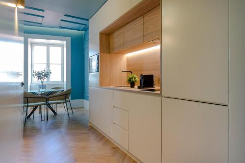 una cucina con armadi bianchi e tavolo da pranzo di HM - Infante Riverside Apartment N a Porto