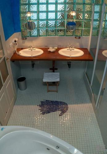 a bathroom with two sinks and a bath tub at Posada torre del milano in Comillas