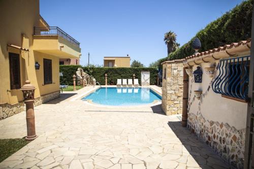 una piscina en un patio junto a una casa en Dimora Fanale, Villa Esclusiva con Piscina Privata - Fanale Rentals en Altavilla Milicia