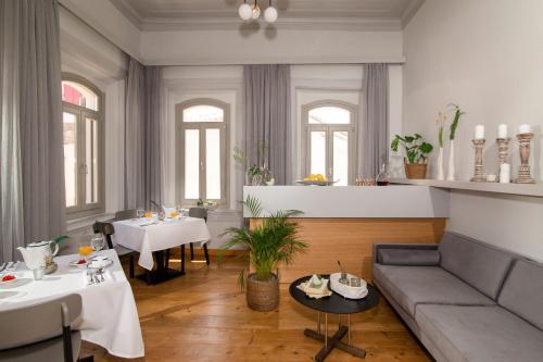 a living room with a couch and tables and windows at Eressian Hotel & Hammam Spa in Eresos