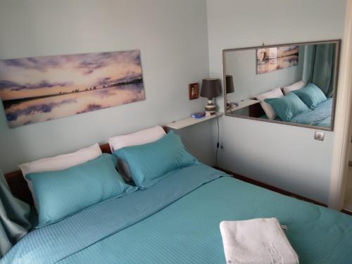 a bedroom with a blue bed and a large mirror at Apartment Galina in Tivat