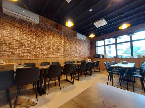 a restaurant with tables and chairs and a brick wall at Otter Hotel in Jinhu