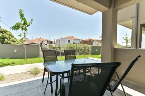 a patio with a table and chairs on a porch at KaSta Family Apartments in Nikiti