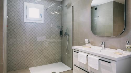 a bathroom with a shower and a sink and a mirror at Mangia's Himera Resort in Campofelice di Roccella