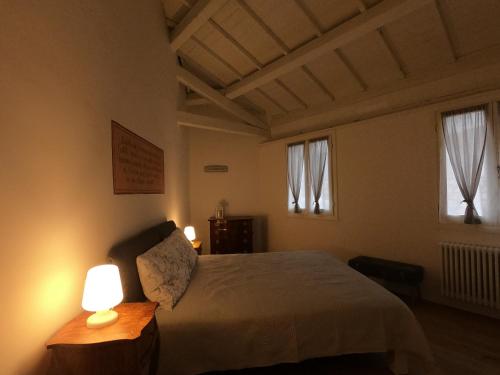 - une chambre avec un lit avec deux lampes et deux fenêtres dans l'établissement Al Vecchio Essicatoio, à Bassano del Grappa