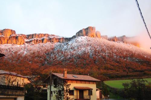 a house in front of a mountain with autumn foliage at Casa Zologorri in Ganuza