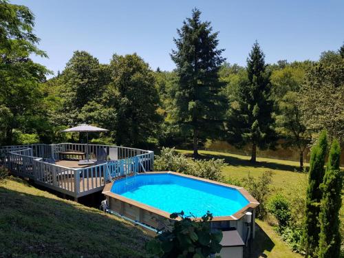a swimming pool in a yard with a deck at Les Deux Lacs - Stunning Gite, with private swimming pool and 2.75 acre fishing lake in La Chapelle-Verlaine