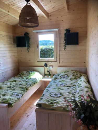 Šluknov的住宿－Domek the luxe，一间卧室设有两张床和窗户。