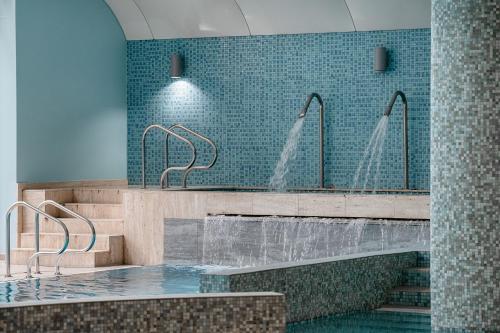 een badkamer met een bad met 2 kranen bij Hotel Uroczysko in Cedzyna