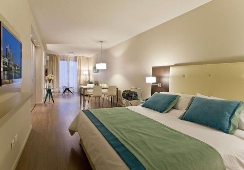 a bedroom with a large bed and a dining room at Bulnes Eco Suites in Buenos Aires