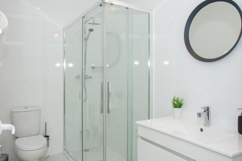 a bathroom with a shower and a toilet and a mirror at Casa da Barca in Vila Nova de Foz Coa