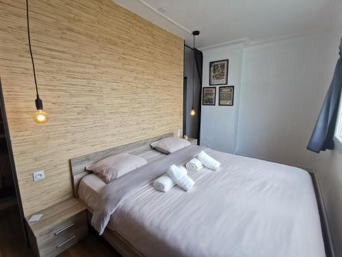 1 dormitorio con 1 cama grande con almohadas blancas en Le Globe-trotter - Les Maisons de Madeleine, en Nantes