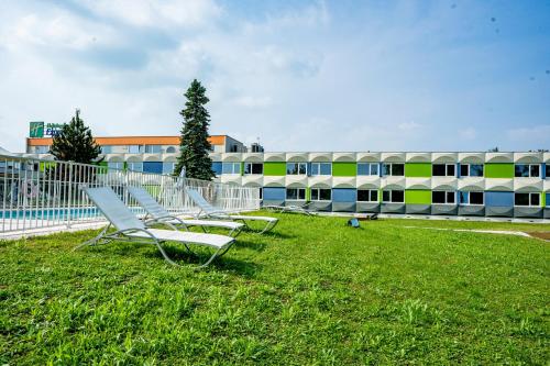 a white plane sitting on top of a grass covered field at Holiday Inn Express Strasbourg - Sud, an IHG Hotel in Geispolsheim