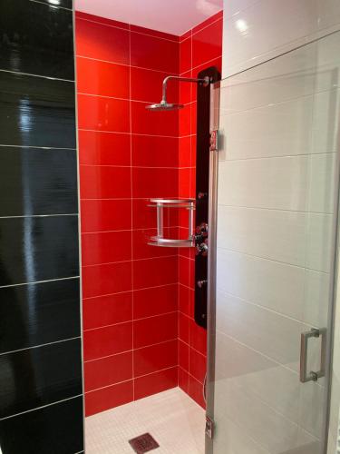 ducha con azulejos rojos y pared roja en Tunel10, en Zamora