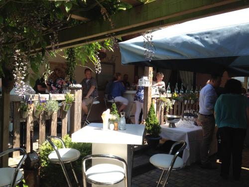 a group of people sitting at tables in a garden at Bed & Breakfast De Vier Seizoenen in Lisse