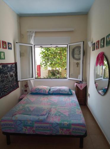 a bedroom with a bed and a window at Lefteris BEAUTIFUL AEGINA in Aegina Town