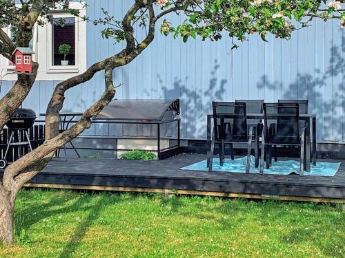 a patio with a table and chairs next to a tree at 6 person holiday home in VISBY in Visby