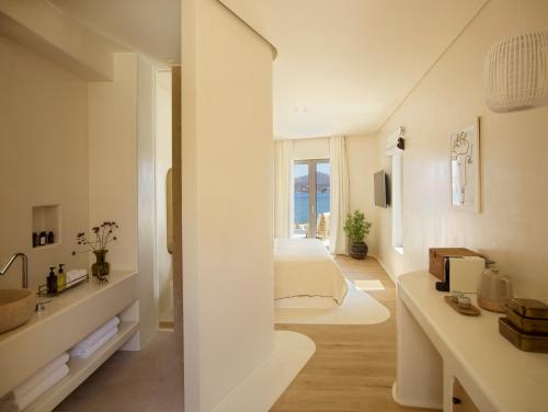 a white bathroom with a white sink and white cabinets at White Pebble Suites in Pollonia