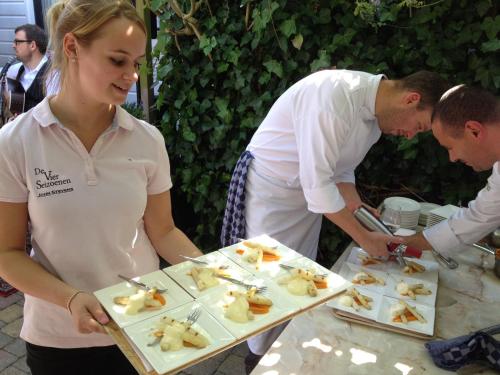 a woman holding a tray of food on a table at Bed & Breakfast De Vier Seizoenen in Lisse