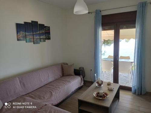 a living room with a couch and a table at Sunset Apartment in Epanomi
