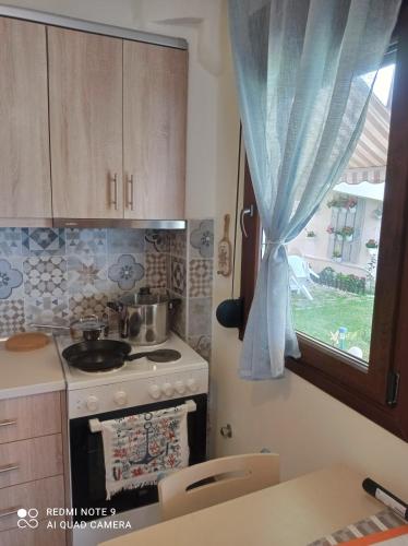 a kitchen with a stove and a window at Sunset Apartment in Epanomi