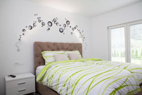 um quarto com uma cama com um edredão verde e branco em Bella Belca em Mojstrana