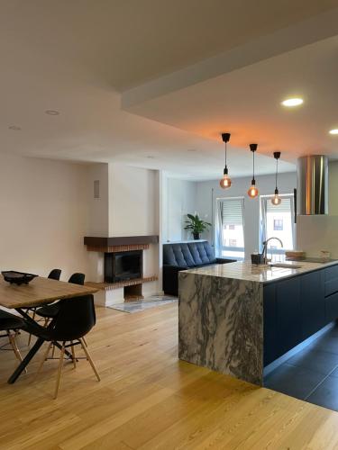 a kitchen and living room with a table and a couch at Casa da Sofia in Leça da Palmeira