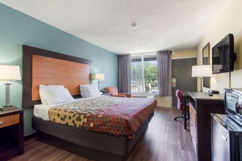 Habitación de hotel con cama y TV en Econo Lodge Gallatin - Metro Nashville, en Gallatin