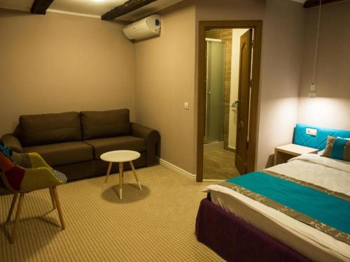 a room with a bed and a couch and a table at CASA GRINDA in Sibiu