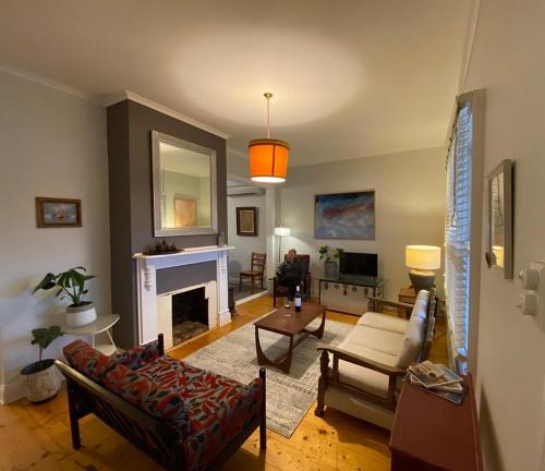 a living room with a couch and a fireplace at Loose Leaf Cottage in Kyneton