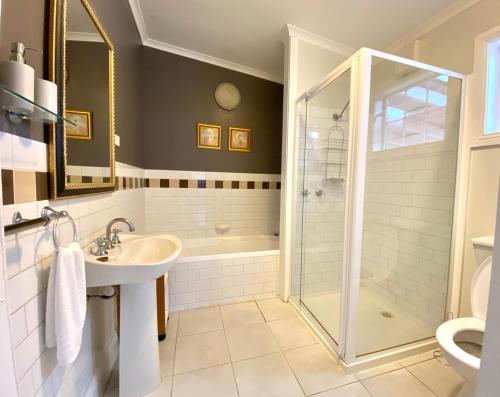 a bathroom with a shower and a sink and a toilet at Loose Leaf Cottage in Kyneton