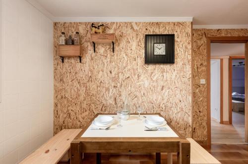 a dining room with a table and a wall at Zumaiako Txapitula - BasKey rentals in Zumaia