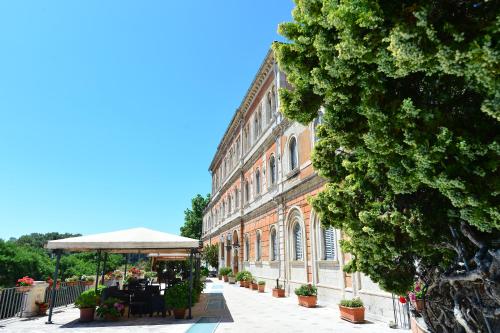 a large brick building with a table and an umbrella at Hotel Iris in Perugia