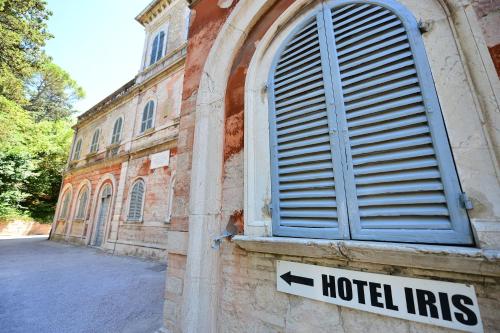 a sign on the side of a building with a hotel hits at Hotel Iris in Perugia