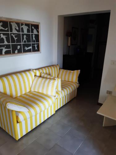 a yellow and white couch in a living room at Le Case Punta Negra in Stintino