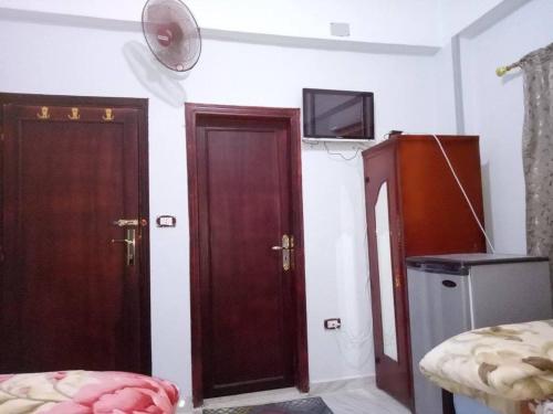 - une chambre avec deux portes en bois et une télévision murale dans l'établissement Kelany Hotel, à ‘Izbat Zaydān