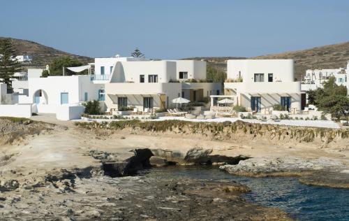 a group of white buildings on a rocky beach at White Pebble Suites in Pollonia