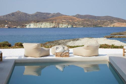 a table with pillows and a view of the ocean at White Pebble Suites in Pollonia