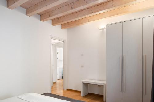 una camera da letto con armadio bianco e soffitto in legno di MyPlace Padova Centro Storico a Padova