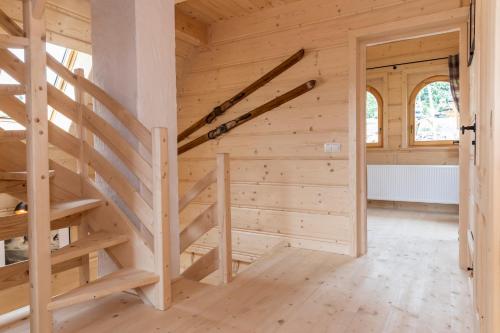 a wooden staircase in a room with wooden walls at udanypobyt Tatrzańskie Domy in Kościelisko