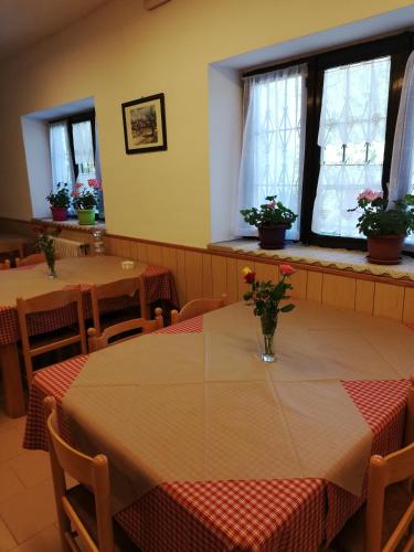 a dining room with tables with flowers on them at Casa per ferie BeatoRosaz in Cesana Torinese