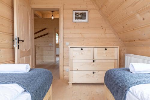 a bedroom with two beds and a dresser at udanypobyt Tatrzańskie Domy in Kościelisko