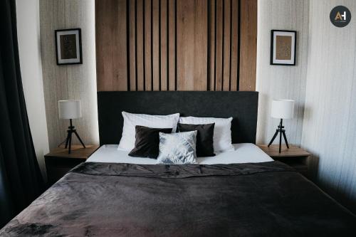 a bedroom with a large bed with two lamps at AH Nová Terasa I in Košice