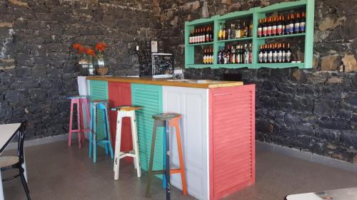 - un bar coloré avec des tabourets colorés dans un restaurant dans l'établissement Hotel Casas do Sol, à São Filipe