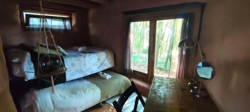 a bedroom with a bed and a table and a window at Associação Quinta das Relvas in Branca