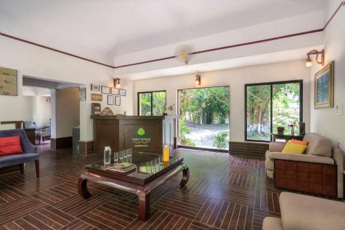 a living room with a couch and a table at The Riverwood Forest Retreat Dooars - fully vaccinated staff in Neorā Nadī